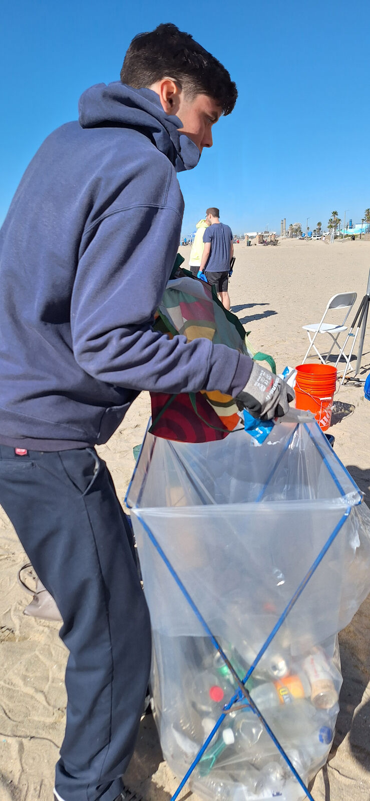 Corpsmember collecting recyclables on the sand at Seal Beach
